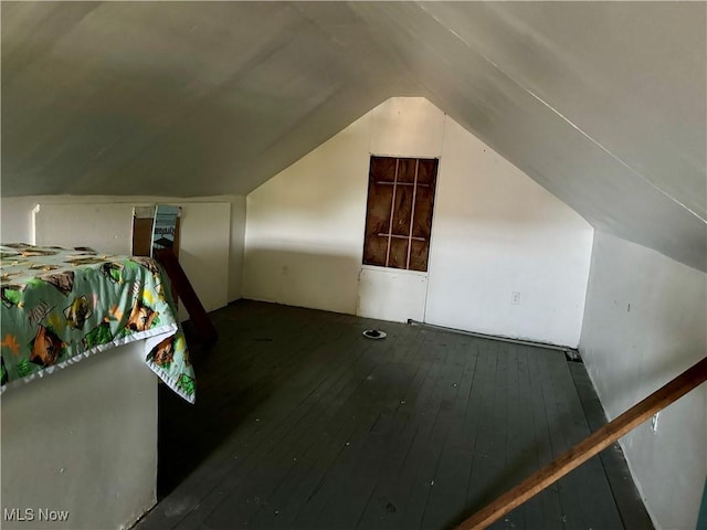 additional living space featuring dark hardwood / wood-style flooring and vaulted ceiling