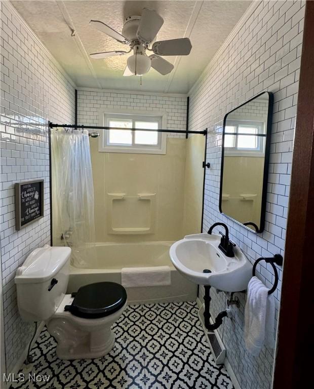 full bathroom with toilet, plenty of natural light, shower / tub combo with curtain, and sink