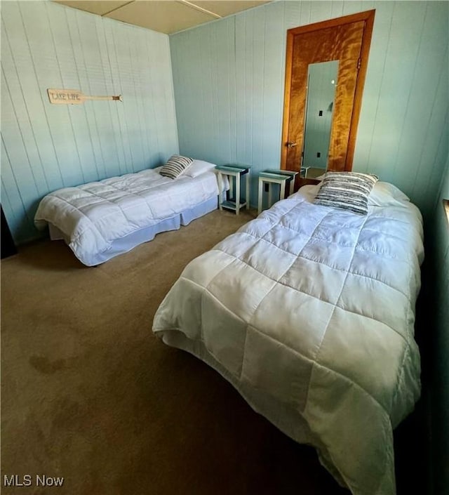 bedroom featuring wood walls, carpet floors, and electric panel