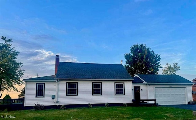 view of front of property with a garage and a lawn