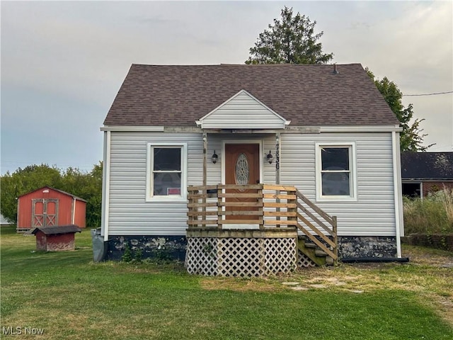 7836 Oak St, Masury, OH 44438 - view of front of house with a front lawn, a wooden deck, an outbuilding, a shingled roof, and a storage unit