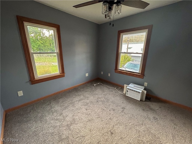 carpeted empty room featuring an AC wall unit, ceiling fan, and a wealth of natural light