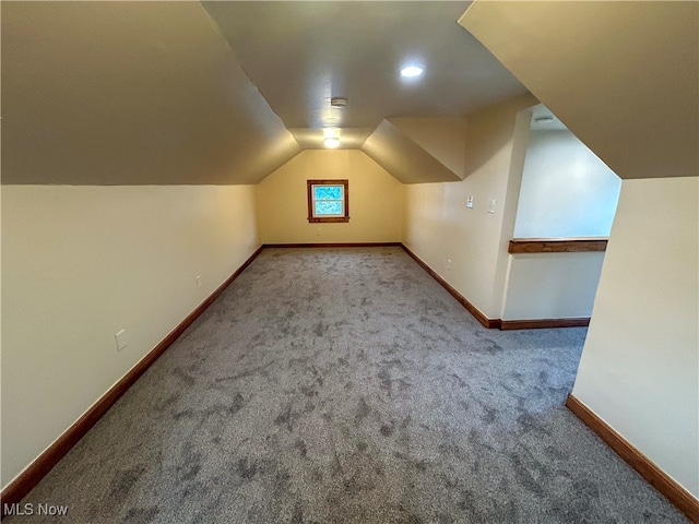 bonus room featuring vaulted ceiling and light colored carpet