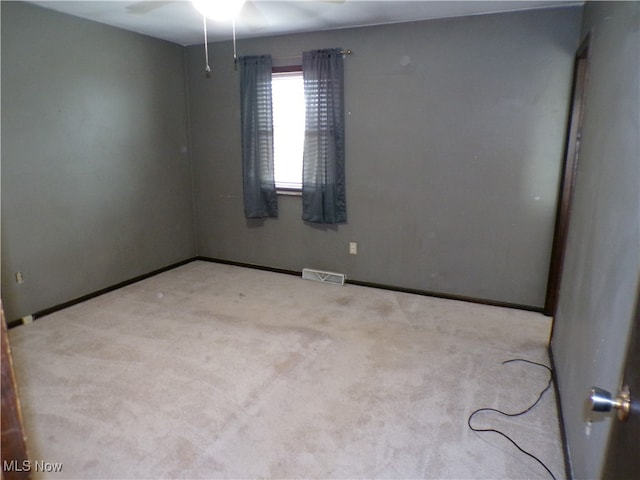 carpeted spare room featuring ceiling fan