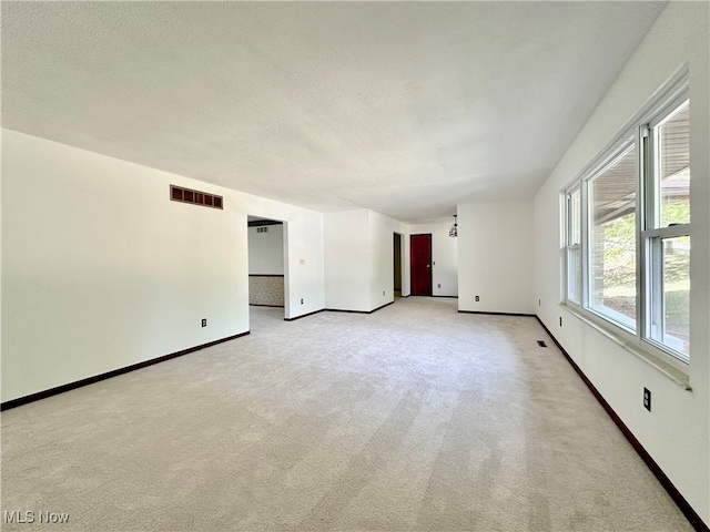 carpeted spare room featuring a textured ceiling