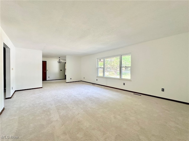 carpeted spare room featuring a textured ceiling