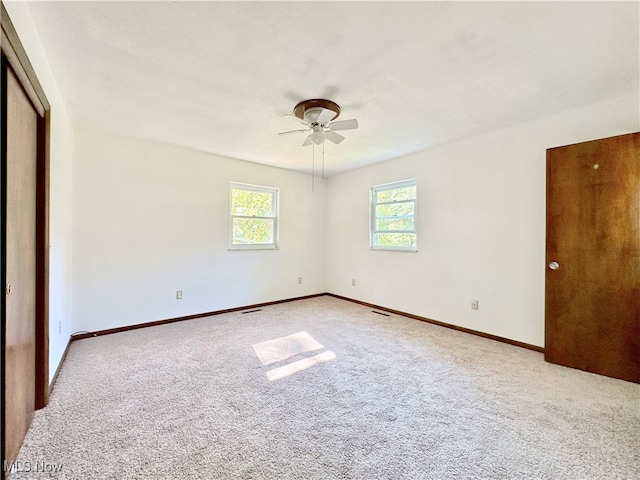 unfurnished bedroom with a textured ceiling, light carpet, and ceiling fan