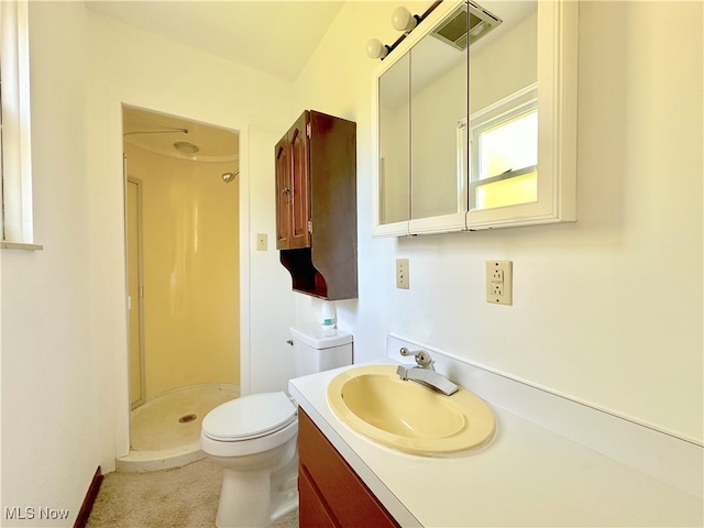 bathroom featuring walk in shower, vanity, and toilet