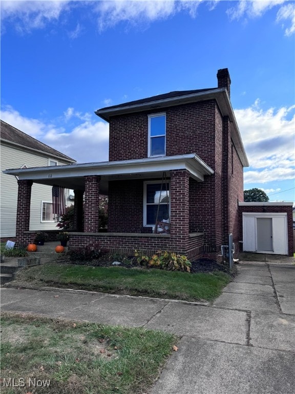 view of front of home featuring a storage shed