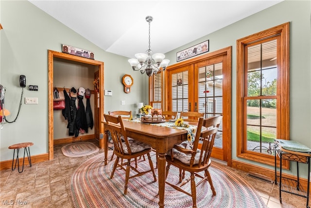 dining space with french doors, vaulted ceiling, a wealth of natural light, and a notable chandelier