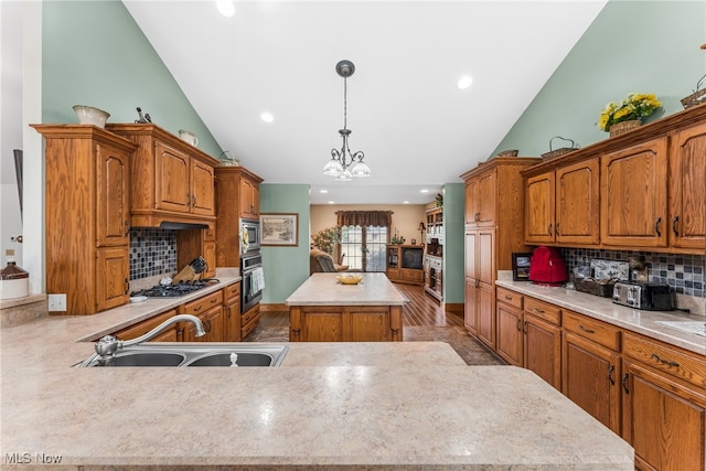 kitchen with sink, hanging light fixtures, light hardwood / wood-style floors, a kitchen island, and stainless steel appliances