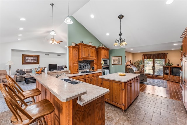 kitchen featuring hanging light fixtures, a spacious island, stainless steel appliances, and a breakfast bar area