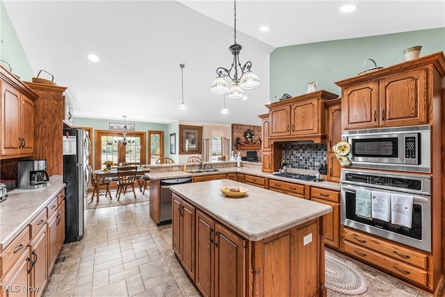 kitchen with kitchen peninsula, stainless steel appliances, decorative light fixtures, an inviting chandelier, and lofted ceiling