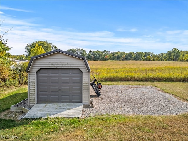 garage with a lawn and a rural view