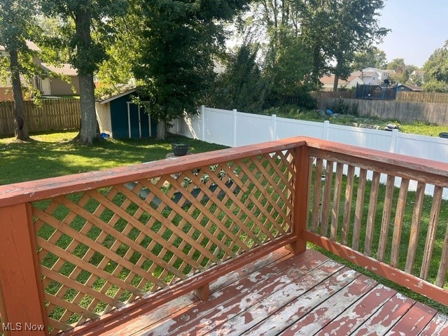 wooden terrace with a lawn and a shed