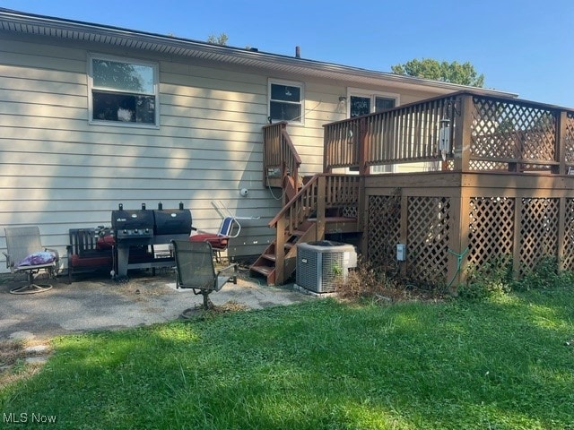 back of property featuring a deck, a yard, a patio area, and central AC