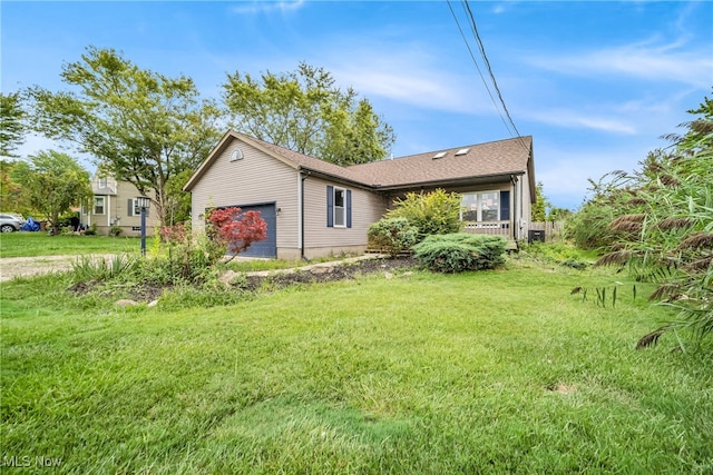 view of side of property with a lawn and a garage