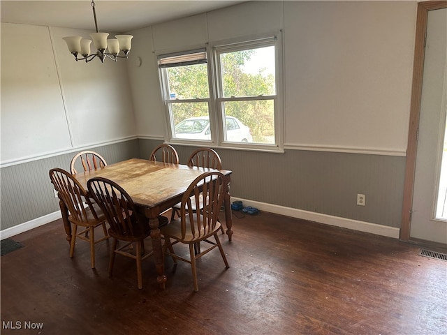 dining area with dark hardwood / wood-style flooring and a chandelier