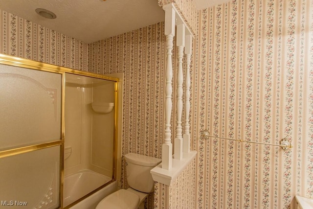 bathroom with enclosed tub / shower combo, a textured ceiling, and toilet