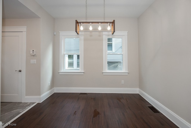 unfurnished dining area featuring dark hardwood / wood-style flooring