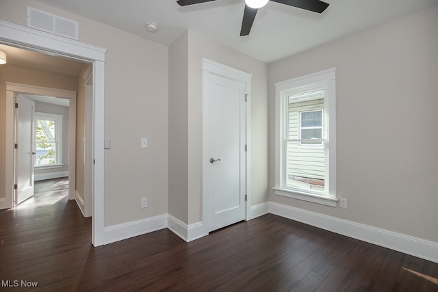 unfurnished bedroom featuring ceiling fan and dark wood-type flooring