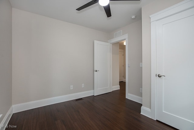 unfurnished bedroom with ceiling fan and dark wood-type flooring