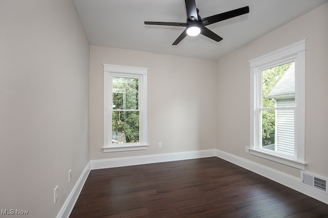 spare room with dark hardwood / wood-style flooring, ceiling fan, and a wealth of natural light