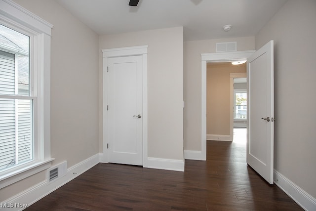 unfurnished bedroom featuring a closet, ceiling fan, and dark hardwood / wood-style flooring