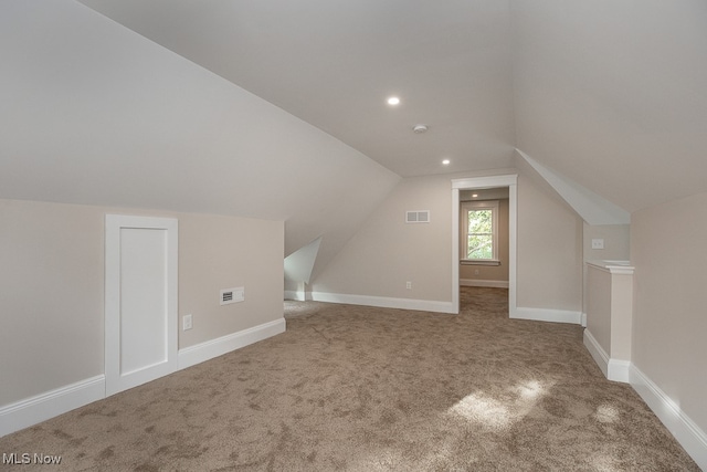 additional living space featuring vaulted ceiling and carpet