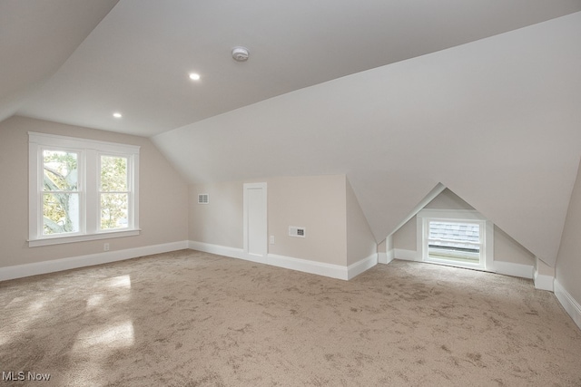 additional living space with carpet floors and vaulted ceiling