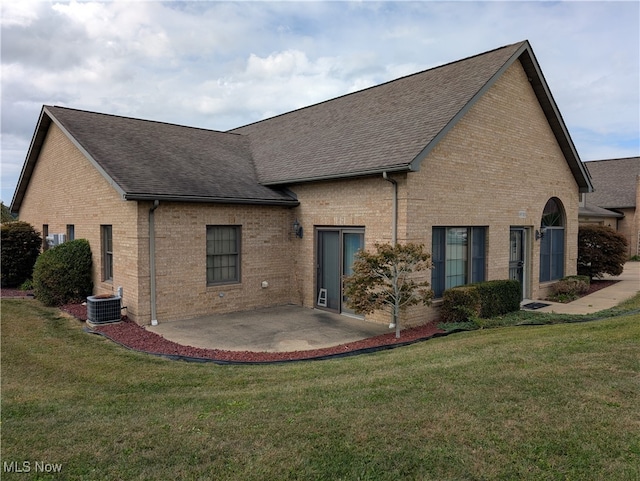 rear view of property with cooling unit, a patio area, and a yard