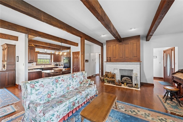 living room with a brick fireplace, beamed ceiling, hardwood / wood-style flooring, and sink