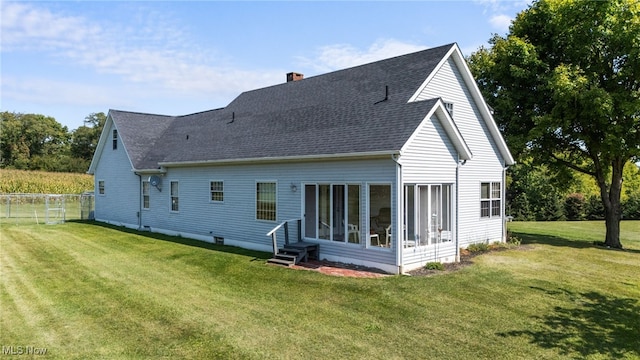 rear view of house featuring a yard