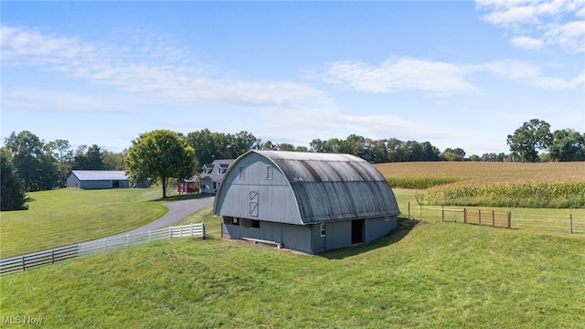 view of outdoor structure with a rural view and a lawn