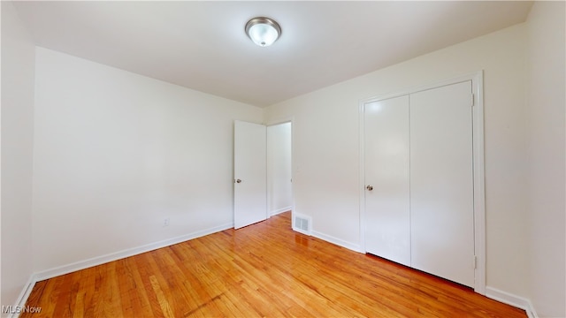 unfurnished bedroom featuring a closet and light hardwood / wood-style floors