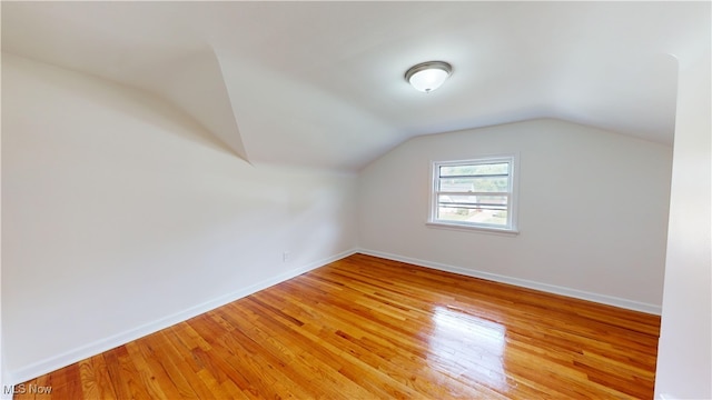 bonus room featuring lofted ceiling and light hardwood / wood-style flooring