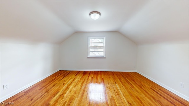 additional living space featuring light hardwood / wood-style floors and vaulted ceiling