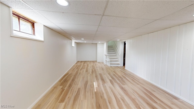 basement with light hardwood / wood-style flooring and a drop ceiling