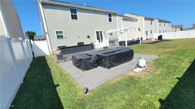 rear view of property with a lawn and a patio