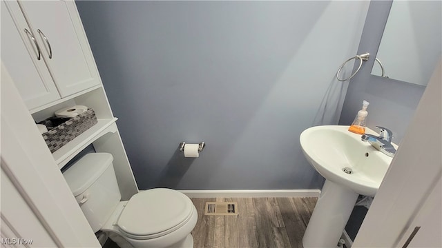 bathroom featuring wood-type flooring and toilet