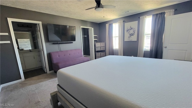 carpeted bedroom featuring a textured ceiling, connected bathroom, and ceiling fan