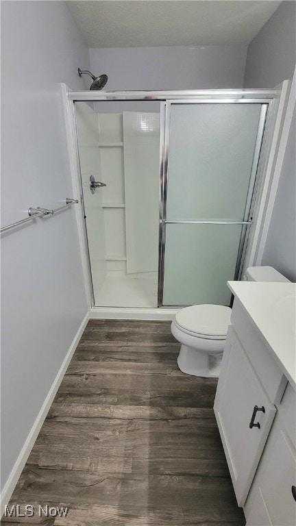 bathroom with vanity, a shower with shower door, and toilet