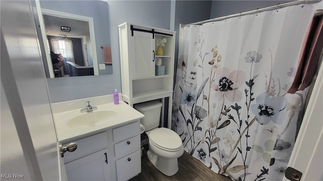 bathroom featuring a shower with curtain, hardwood / wood-style flooring, vanity, and toilet