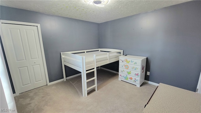 bedroom with light carpet, a closet, and a textured ceiling