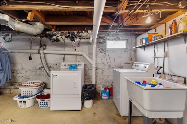 laundry area with laundry area, a sink, and washing machine and clothes dryer