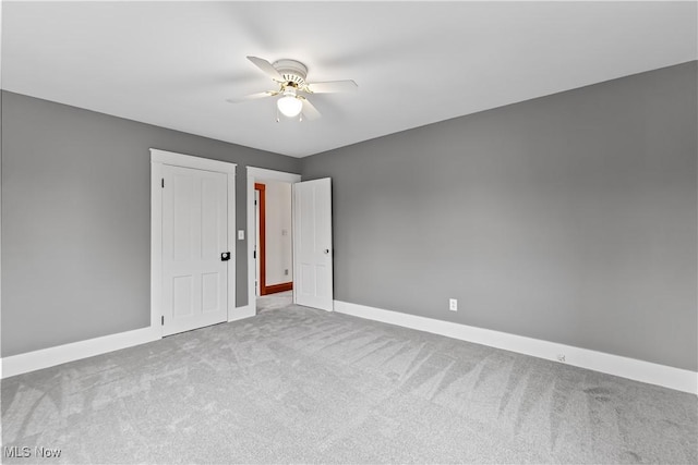 unfurnished room with carpet floors, baseboards, and a ceiling fan