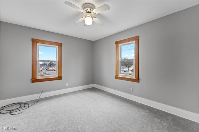 unfurnished room featuring carpet flooring, a ceiling fan, and a healthy amount of sunlight