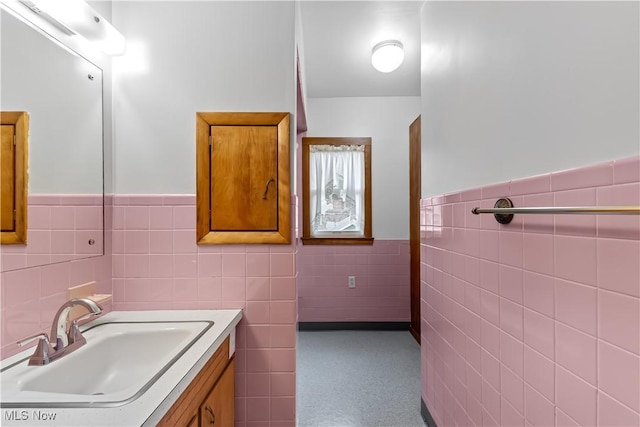 bathroom featuring wainscoting, vanity, and tile walls