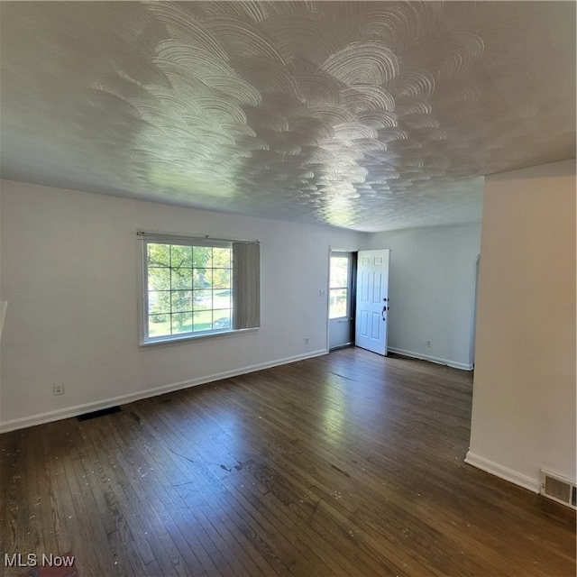 empty room featuring dark hardwood / wood-style floors and a wealth of natural light