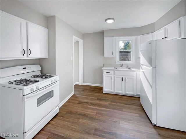 kitchen with white appliances, white cabinetry, sink, and dark wood-type flooring